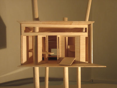 The owner of a large tract of land in Ramatuelle (France) needed a safe place where he could both work and sleep over. Our proposal was to construct a small wooden house (12m2) set above 4 cluster pines. The house opens onto – and closes from – the nature outside thanks to a 'furnished wall' complete with a bucket chaise longue and a foldable work table. The house is accessed via a drawbridge.